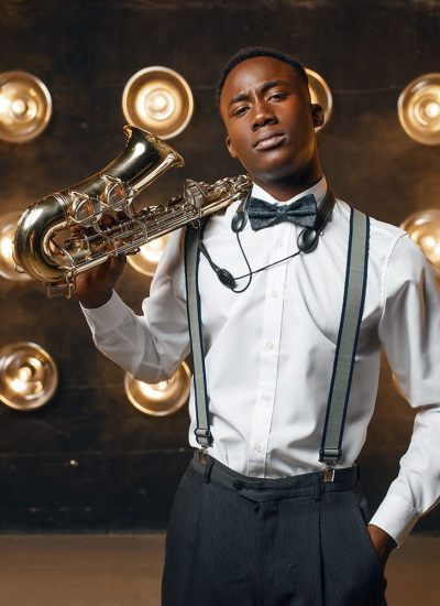 Black jazz performer poses with saxophone on stage